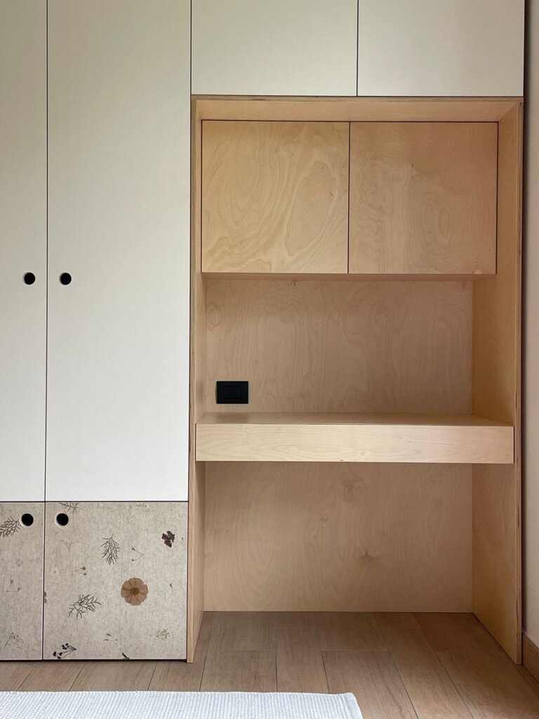 Empty wooden and white cabinets with a black electrical outlet inside the wooden section