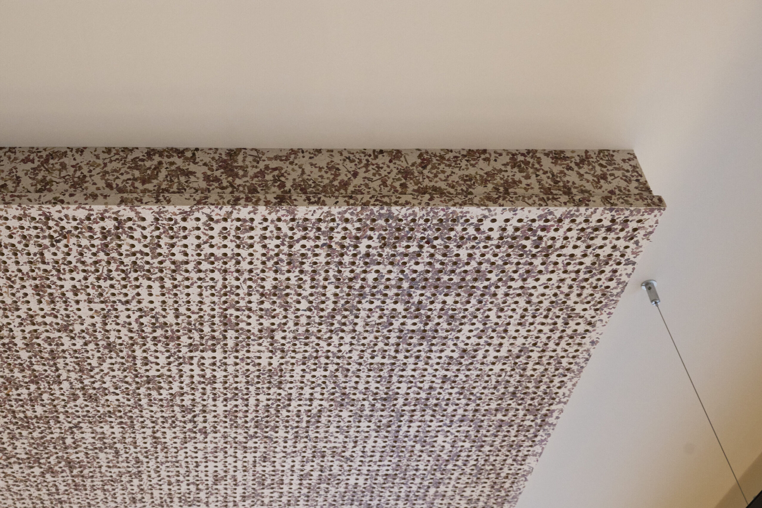 Akustikpaneel mit rosa und braunen Mustern an der Decke