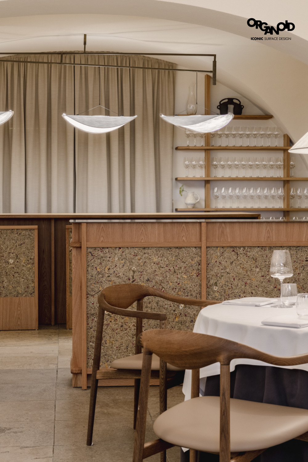 Heller Restaurantbereich mit Holzmöbeln, Geschirr und dekorativen Lampen an der Decke