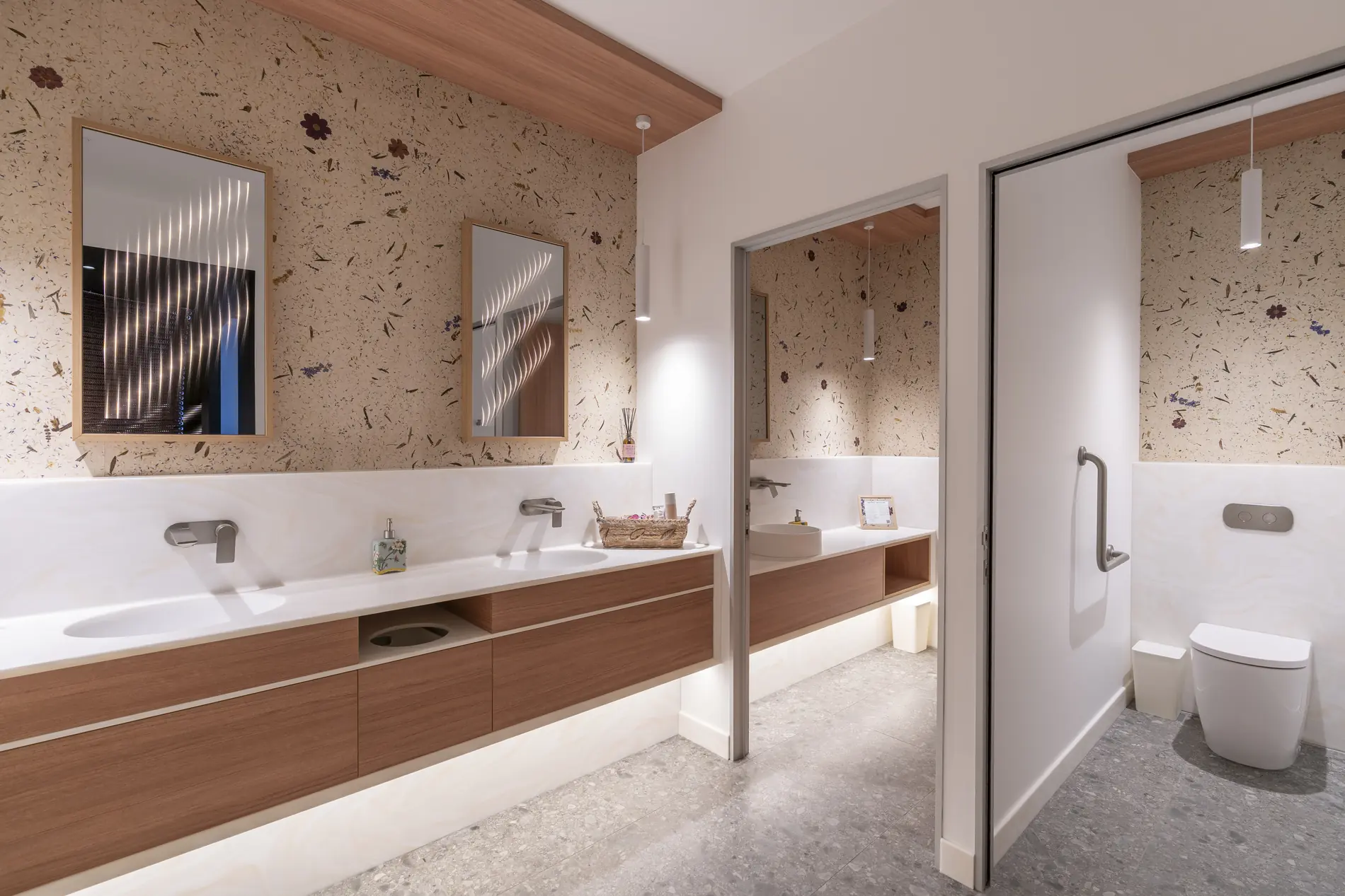 Badezimmer mit Blütenwand aus echten Blumen, Doppelwaschbecken, Spiegel, Handtuchhalter und Toilette, moderne Einrichtung