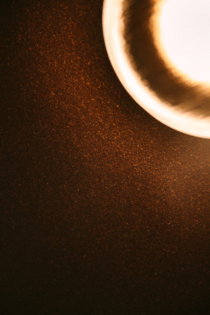 Nahaufnahme eines leuchtenden Gegenstands auf dunklem, körnigem Hintergrund