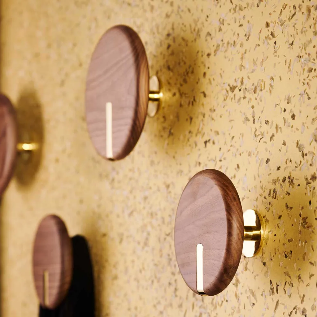 Garderobe mit einer Goldenen Wand mit Hopfenblütenblättern. Wirkt sehr edel.