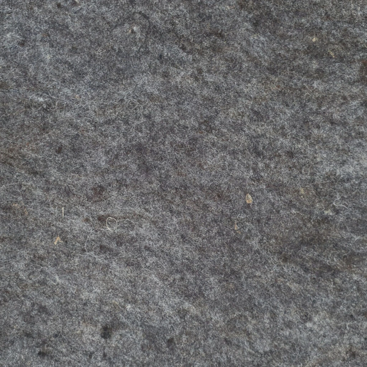 Nahezu quadratische, graue, raue Steinoberfläche mit kleinen Staub- und Fusselresten