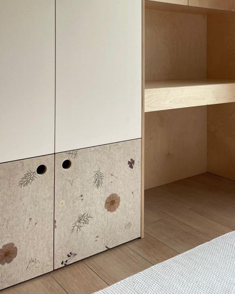 Wooden cabinet with floral and leaf patterns on the lower doors and plain upper doors