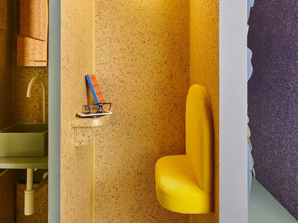 Eine Büro Ecke mit einer Sitzmöglichkeit und einer goldenen Wand mit Blättern.